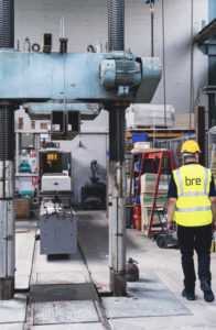 BRE testing staff standing next to industrial testing equipment